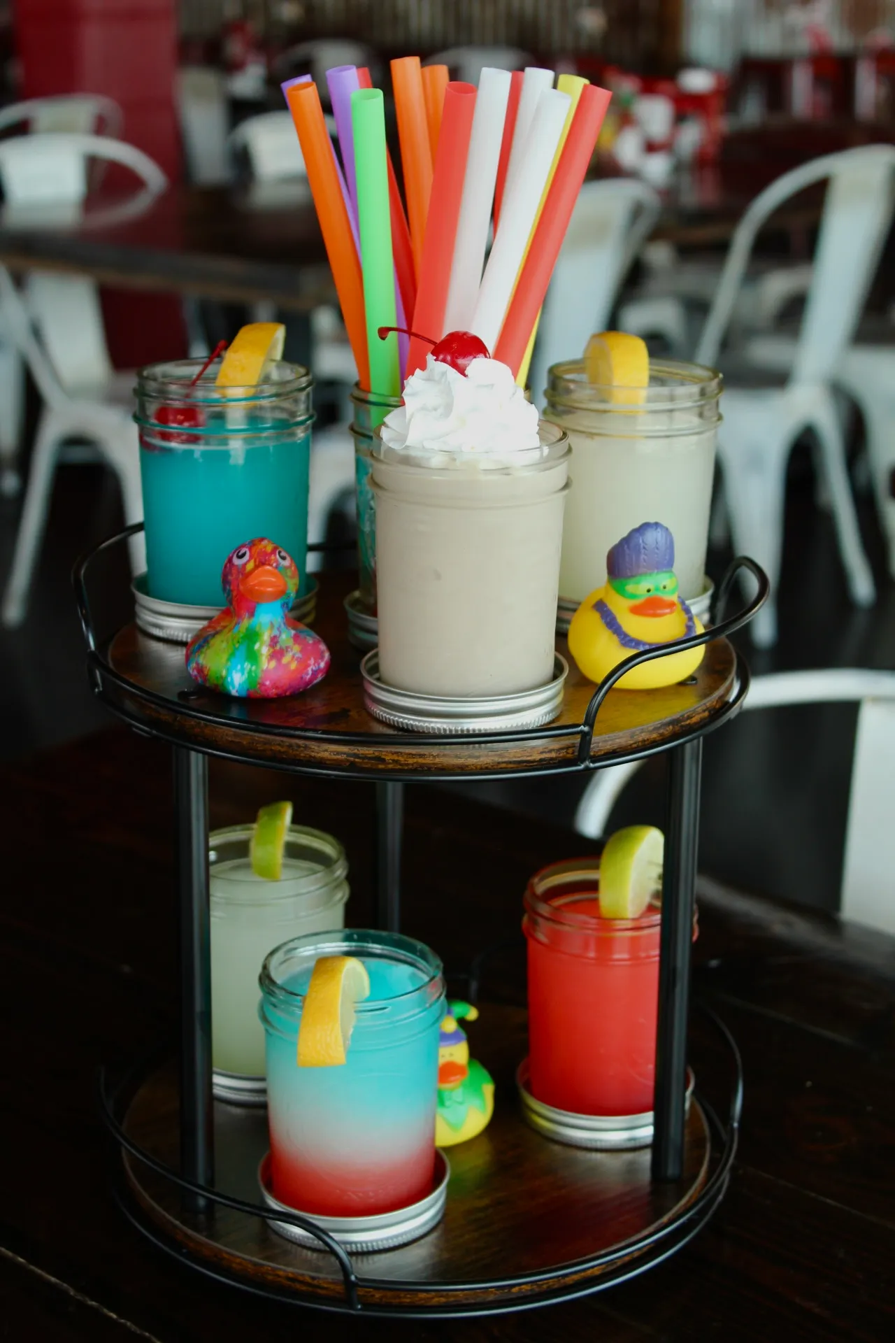 A colorful flight of slushies with various flavors and a cherry on top.