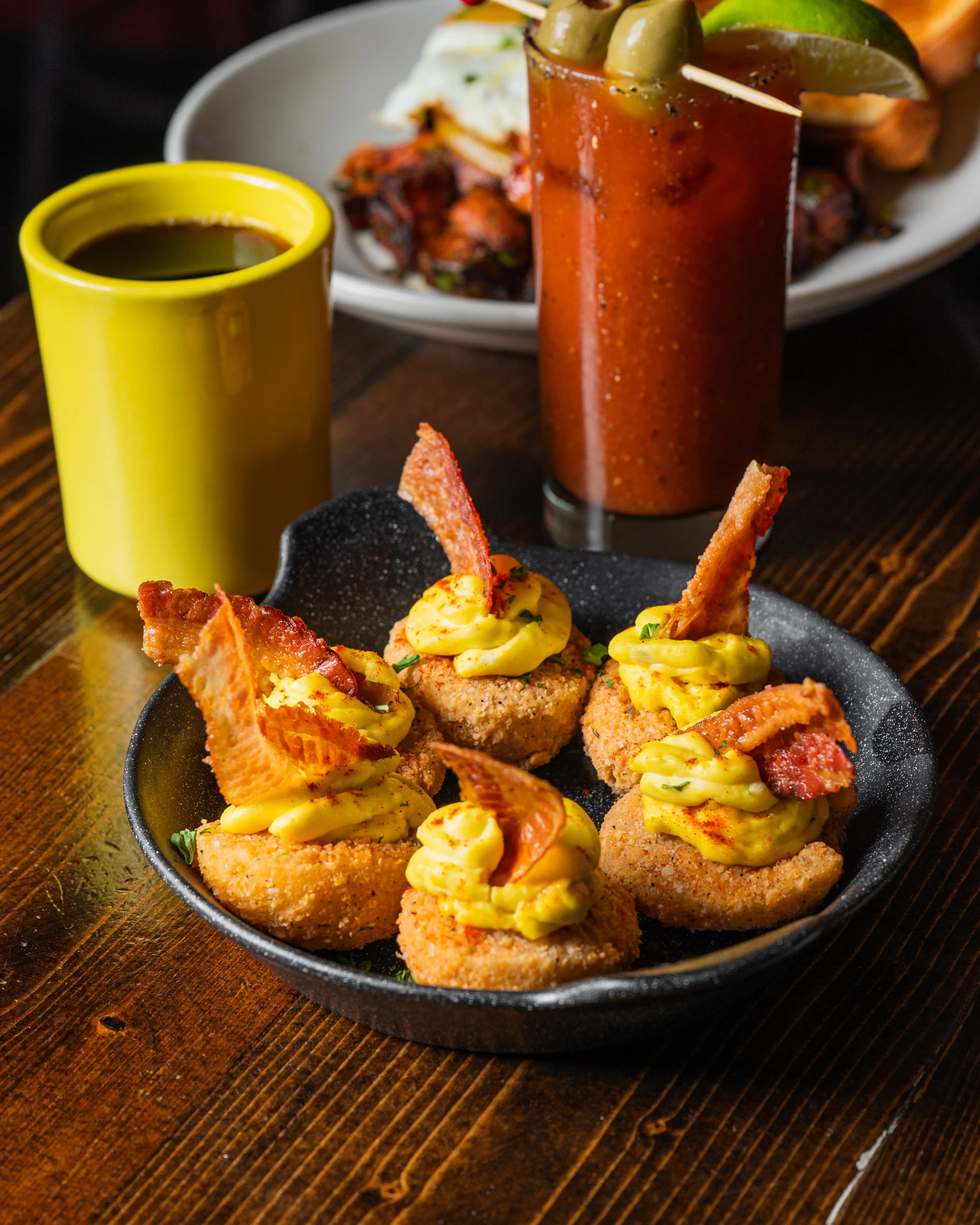 Golden fried deviled eggs topped with bacon and mustard