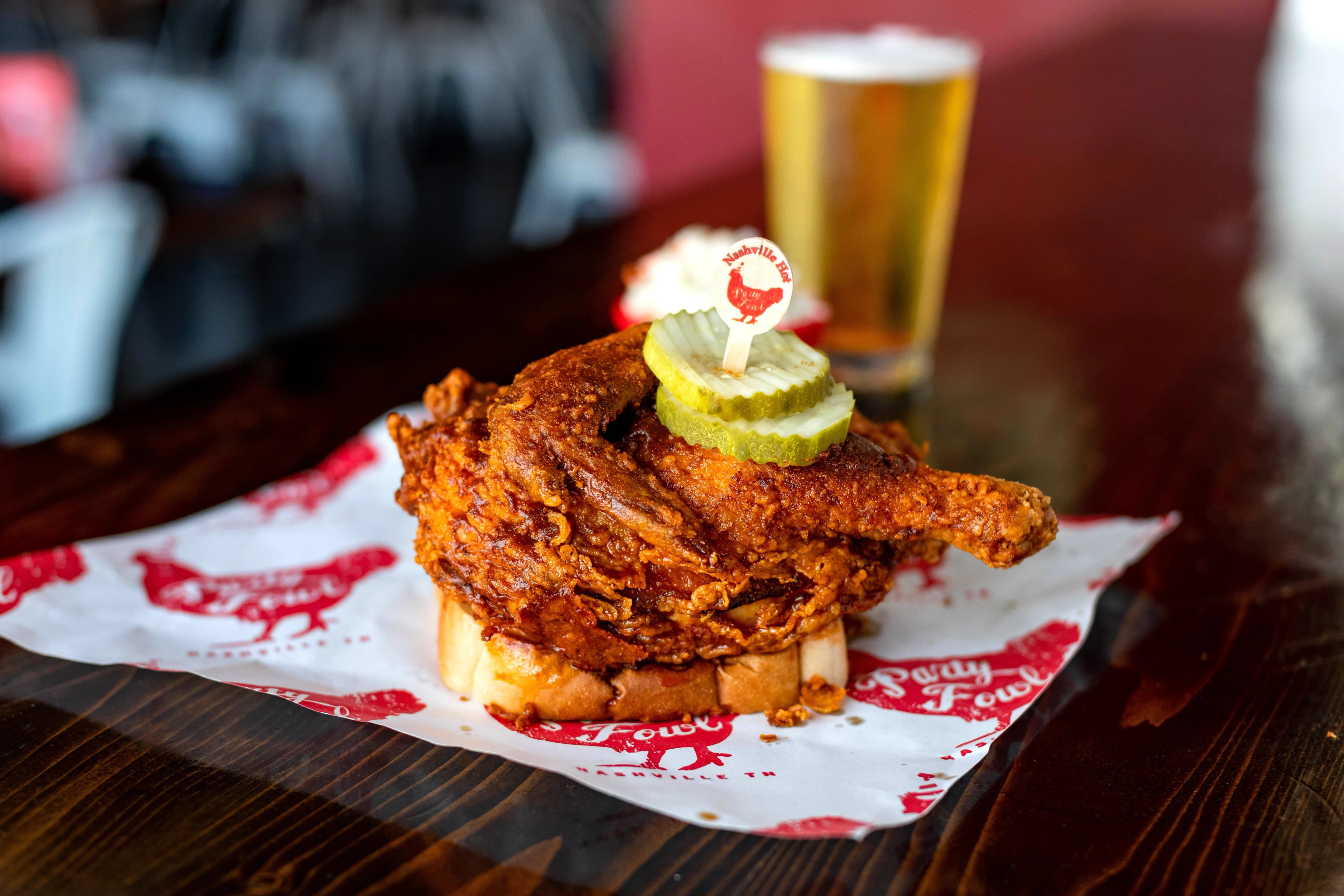 A crispy fried chicken sandwich topped with pickles and a toothpick