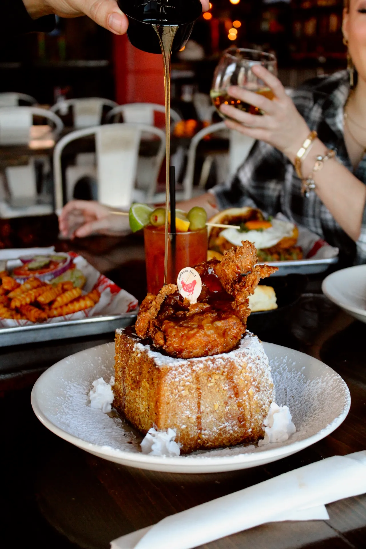 A plate of stuffed French toast topped with fried chicken