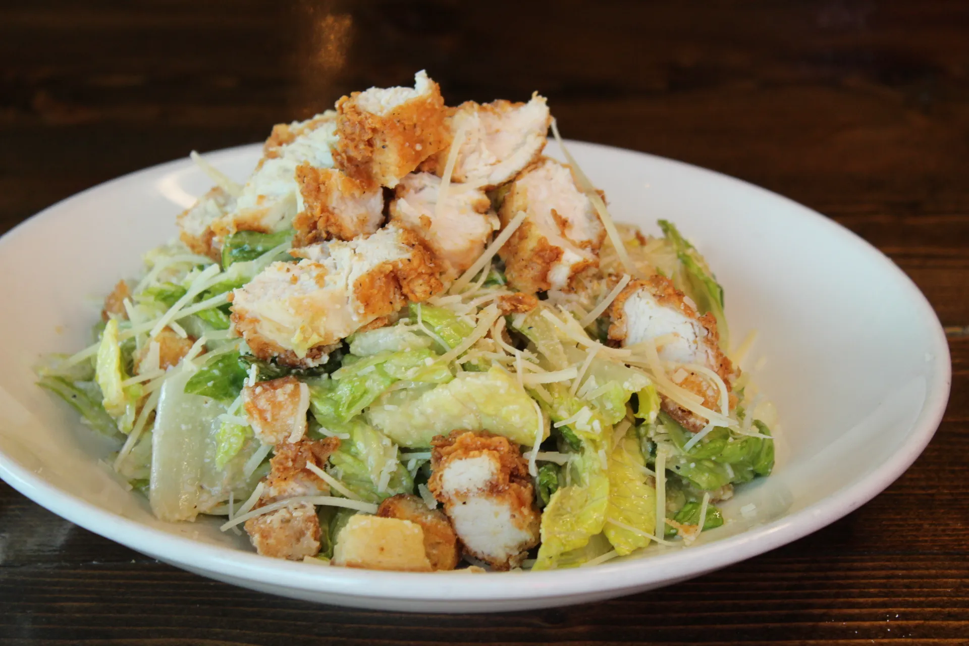 Chicken Caesar Salad A fresh salad topped with crispy chicken, croutons, and grated Parmesan cheese.