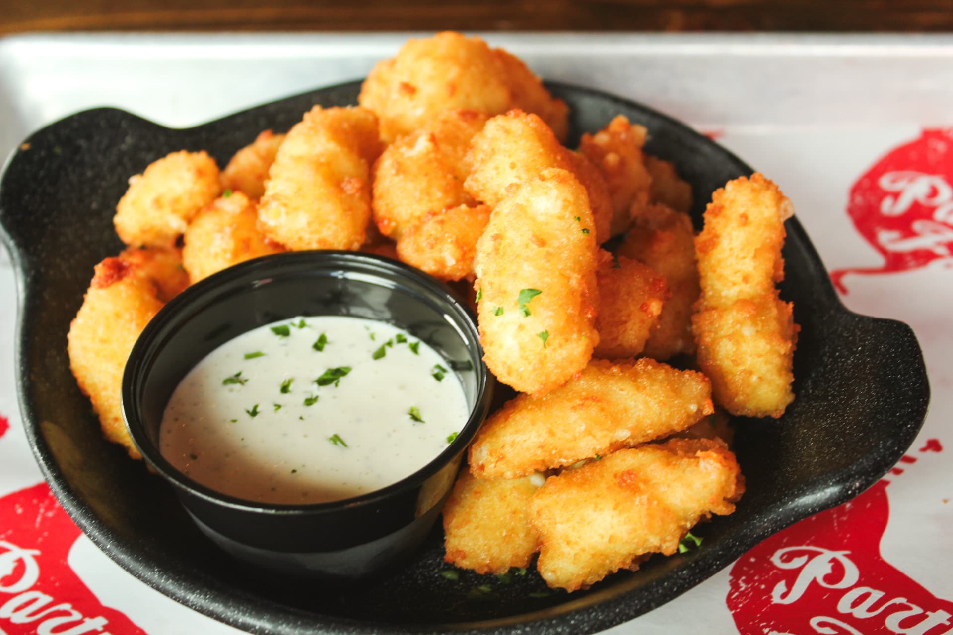 Fried Cheese Curds Golden fried cheese curds served with a side of creamy dipping sauce.