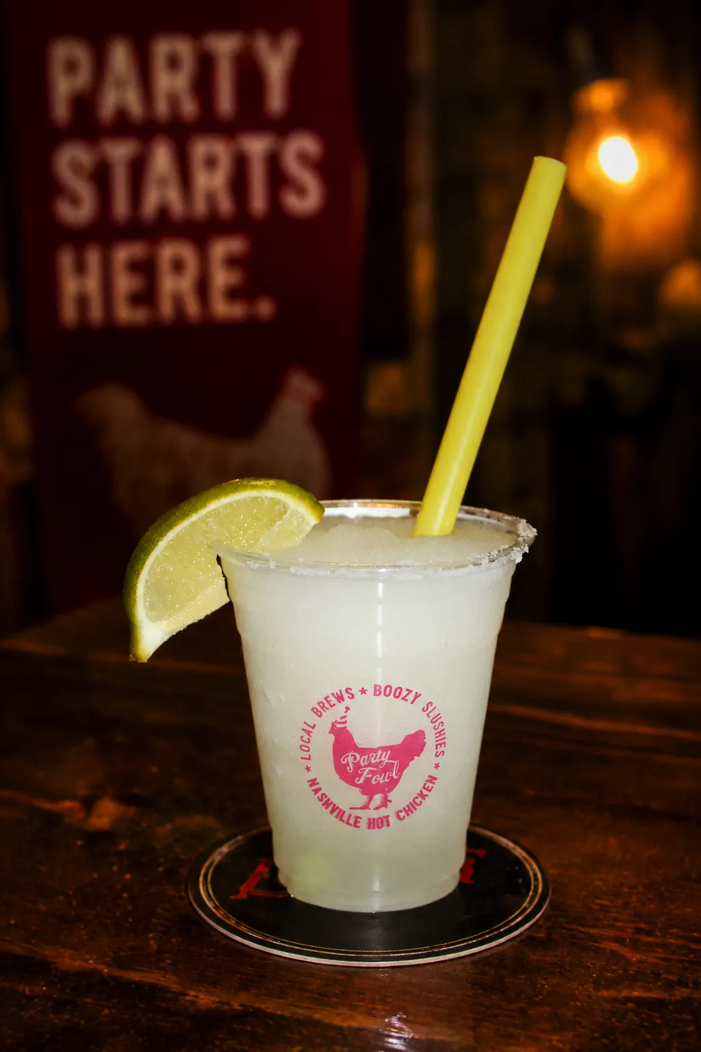 Margarita A refreshing margarita garnished with a lime slice and served in a branded cup with a straw