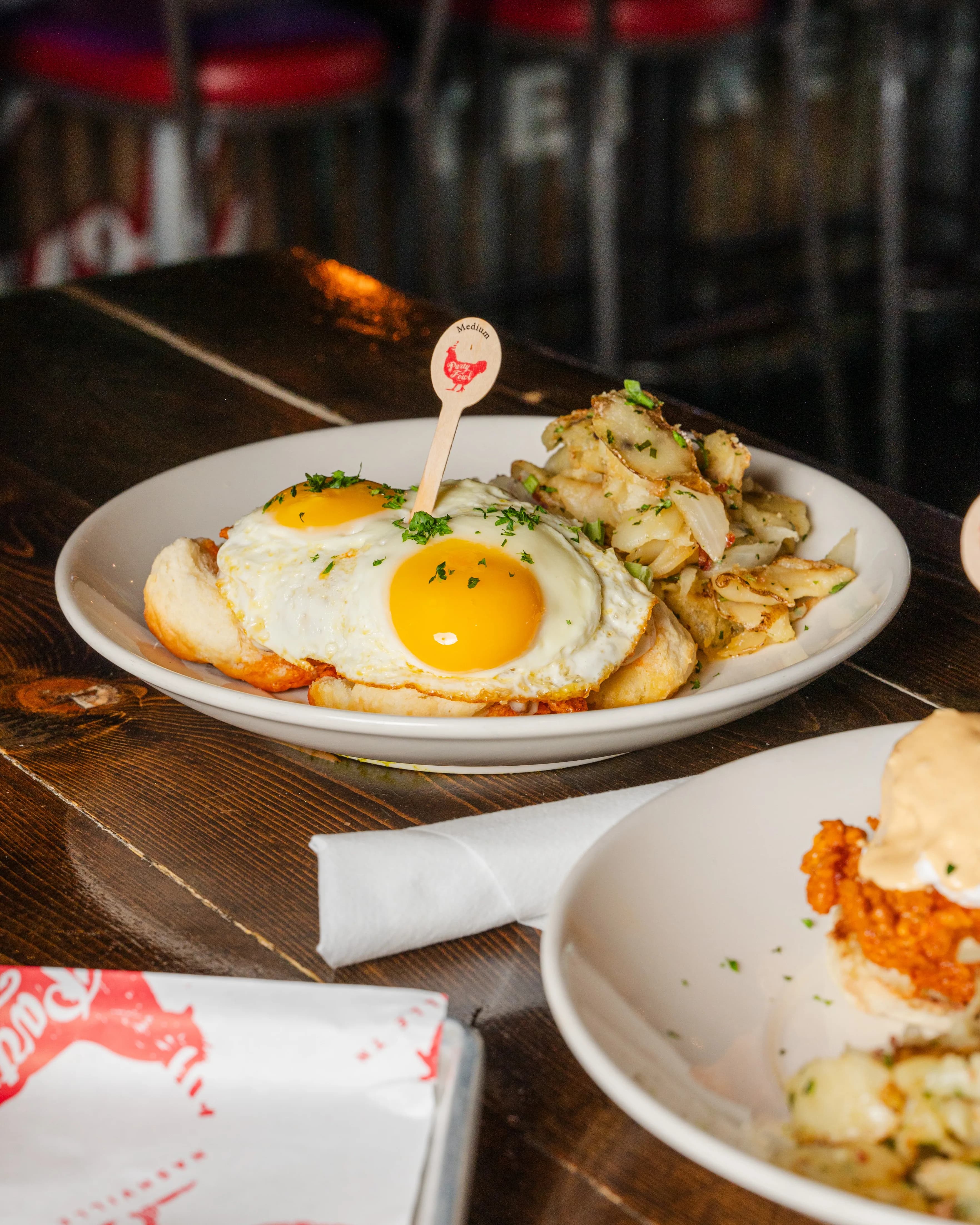 Biscut A hearty breakfast plate featuring a biscuit topped with a sunny-side-up egg and garnished with herbs