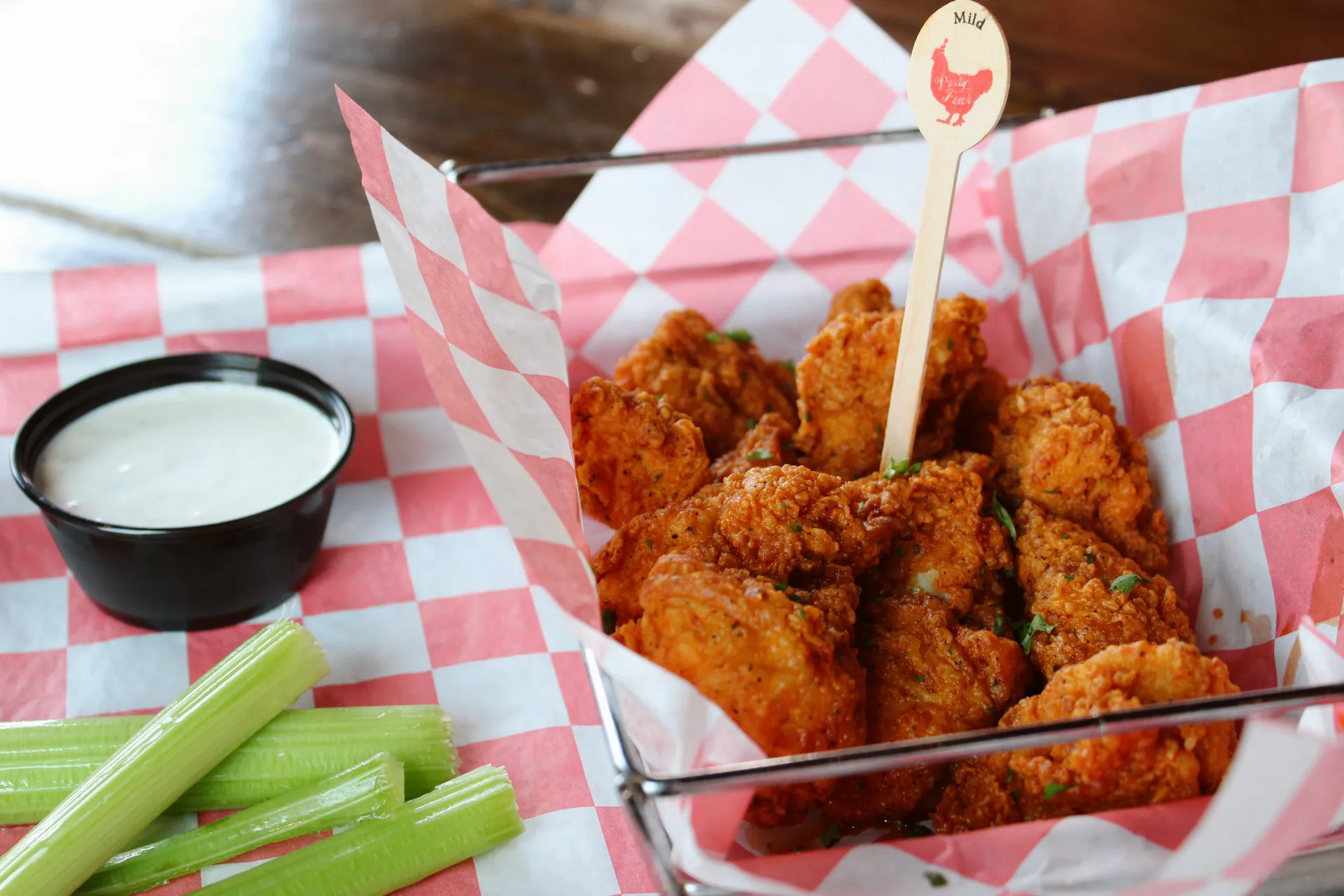 Boneless12wings A basket of crispy boneless wings served with celery sticks and a side of ranch dressing.