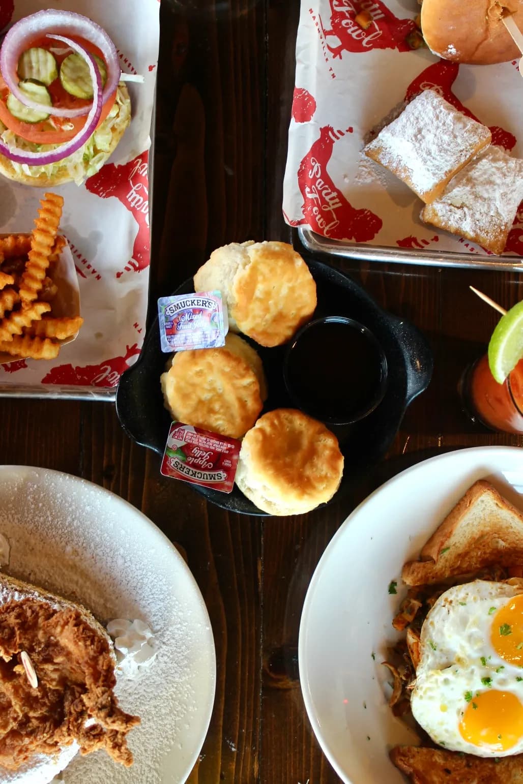 Buttermilk Biscuits A plate of golden-brown buttermilk biscuits served with jam and butter, surrounded by other breakfast dishes.