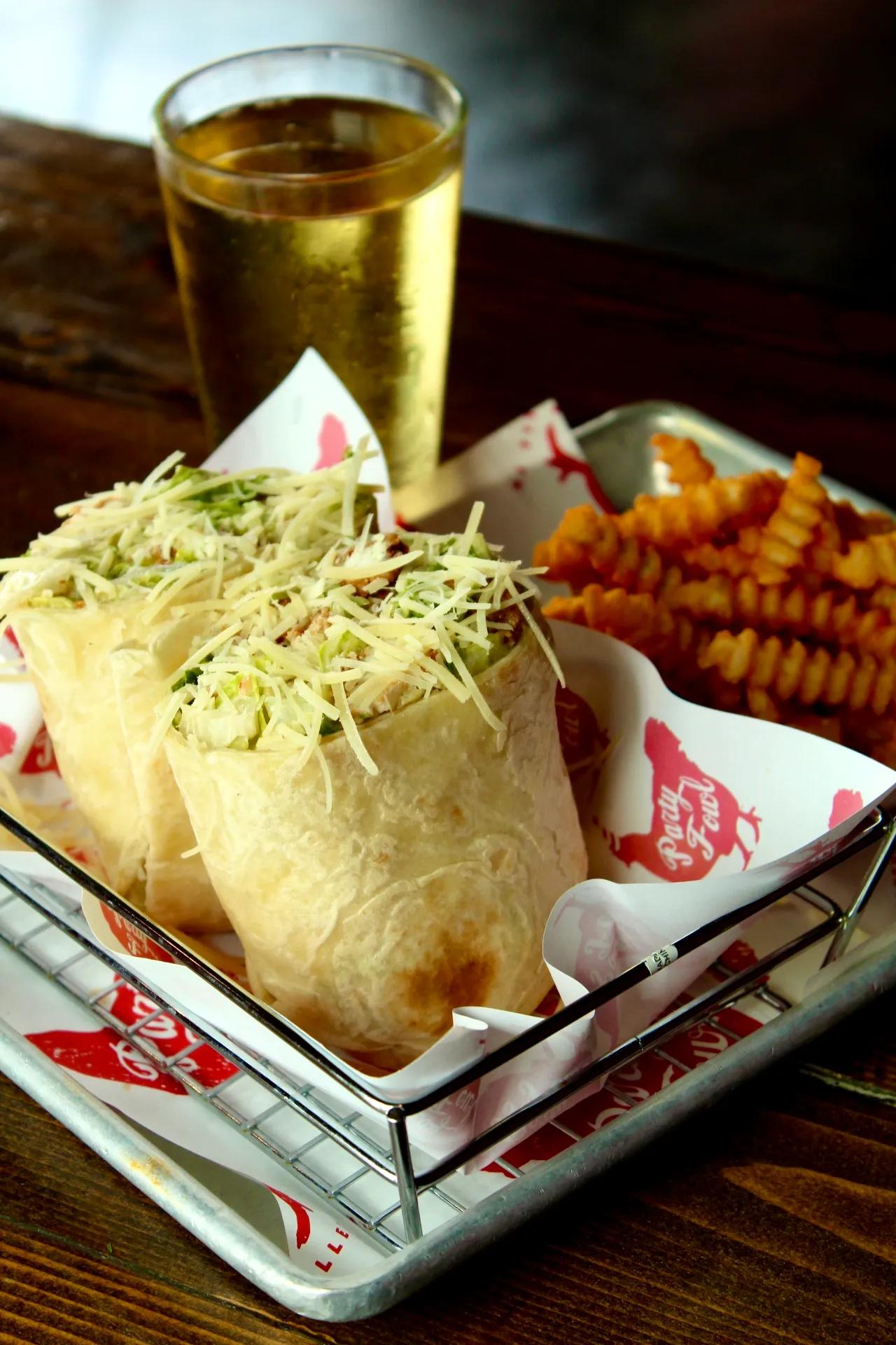 Chicken Caesar Wrap 2 A crispy chicken Caesar wrap topped with shredded cheese, served with curly fries and a drink.