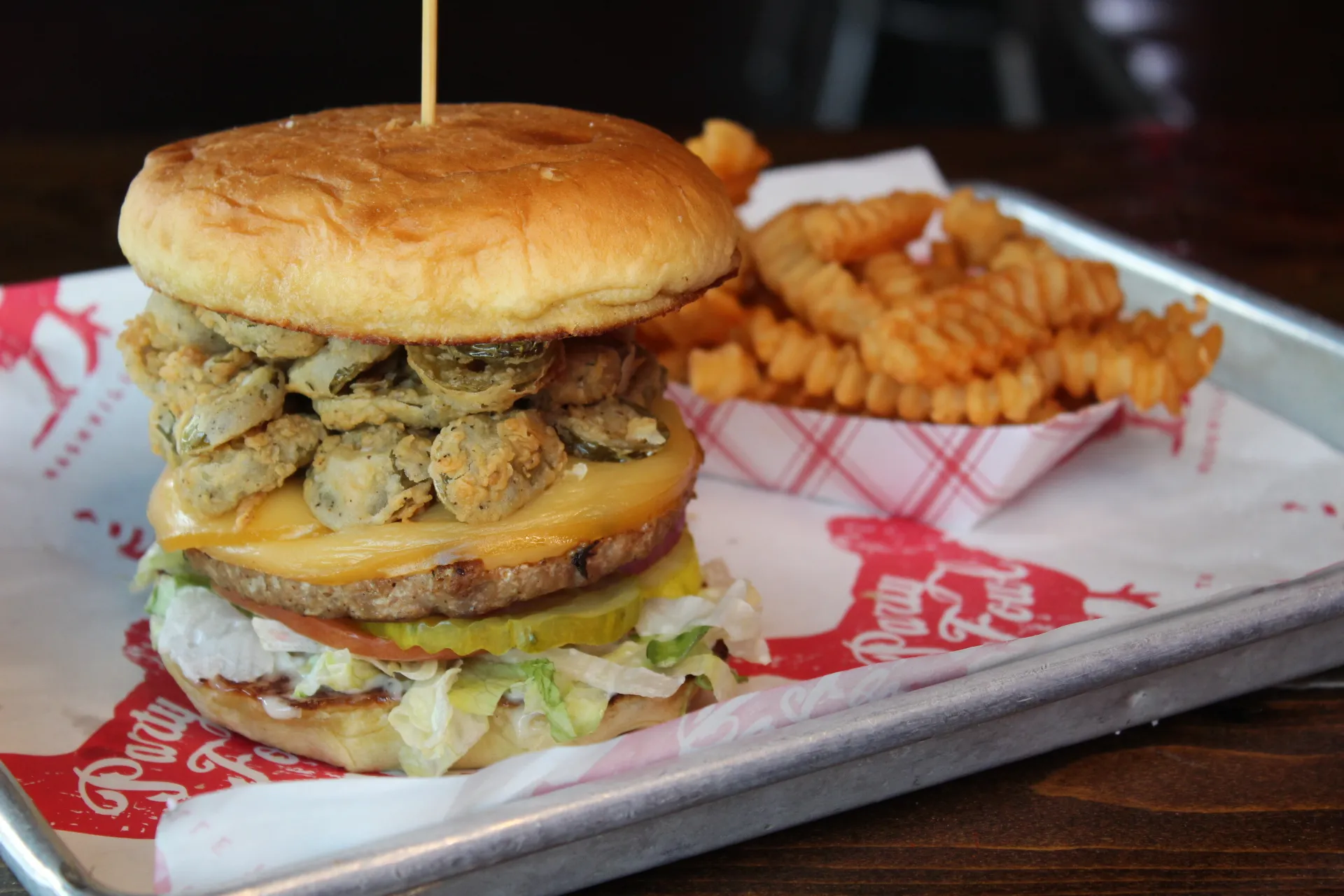 Turkeyburger A hearty turkey burger topped with fried pickles, cheese, and fresh toppings, served with curly fries.